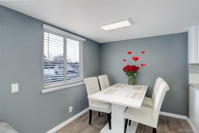 dining space featuring baseboards and wood finished floors