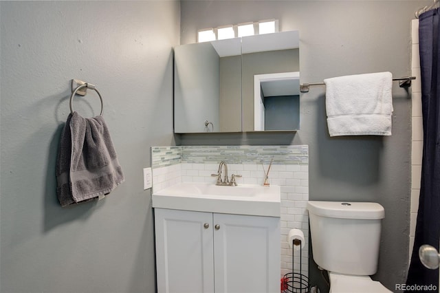 bathroom featuring toilet, vanity, and decorative backsplash