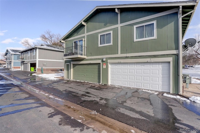 view of front facade featuring an attached garage and a balcony