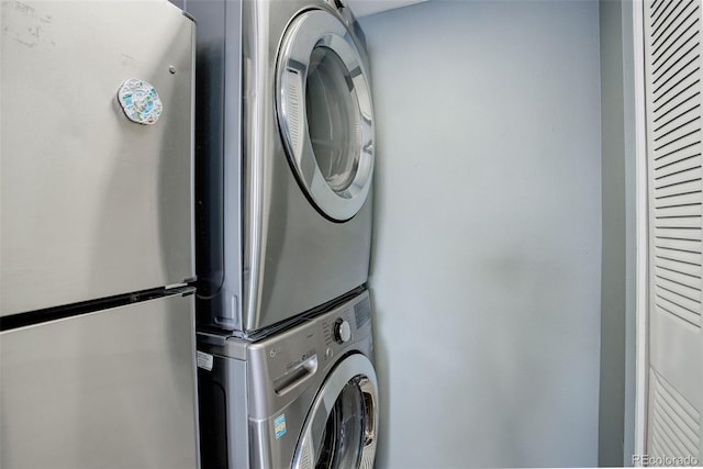 clothes washing area with stacked washer and clothes dryer and laundry area