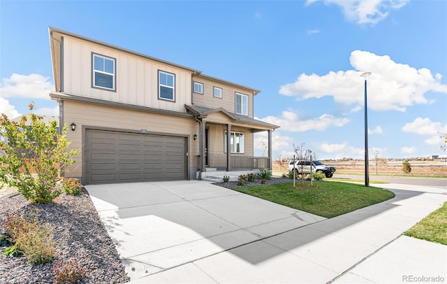 view of front facade with a garage, a front yard, and covered porch