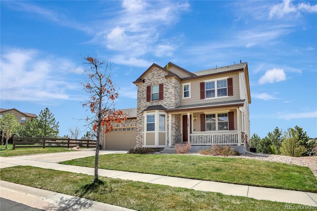 view of front of house with a front lawn, fence, covered porch, stone siding, and driveway