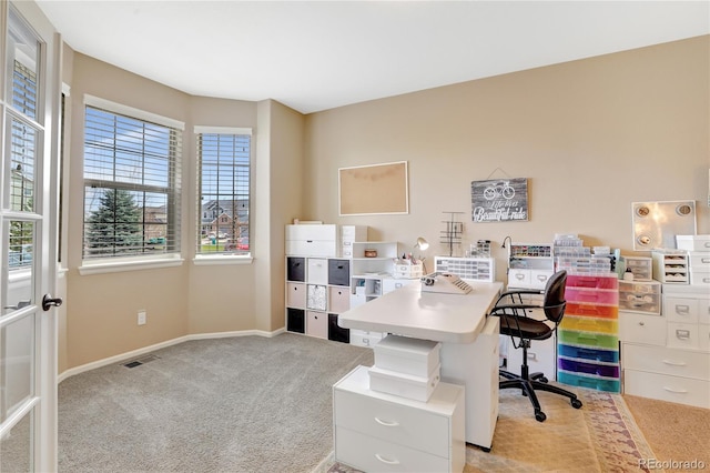 carpeted office space with baseboards, visible vents, and a wealth of natural light