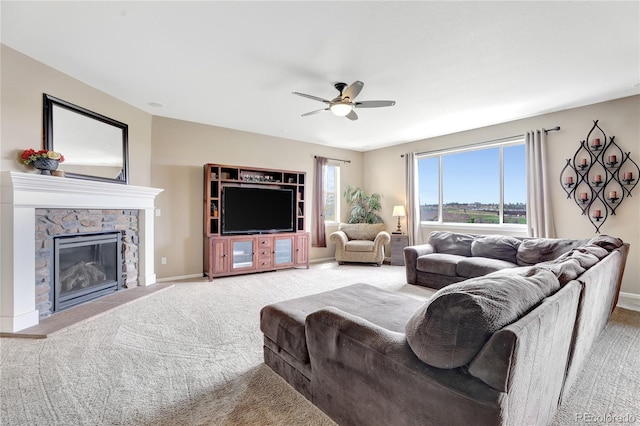 living area with a ceiling fan, baseboards, light colored carpet, and a fireplace