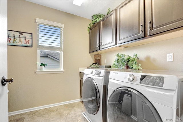 laundry area featuring baseboards, cabinet space, light tile patterned floors, and washing machine and clothes dryer