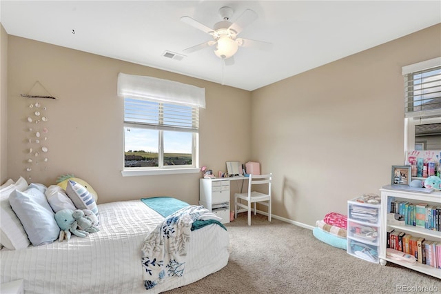 carpeted bedroom with baseboards, a ceiling fan, and visible vents