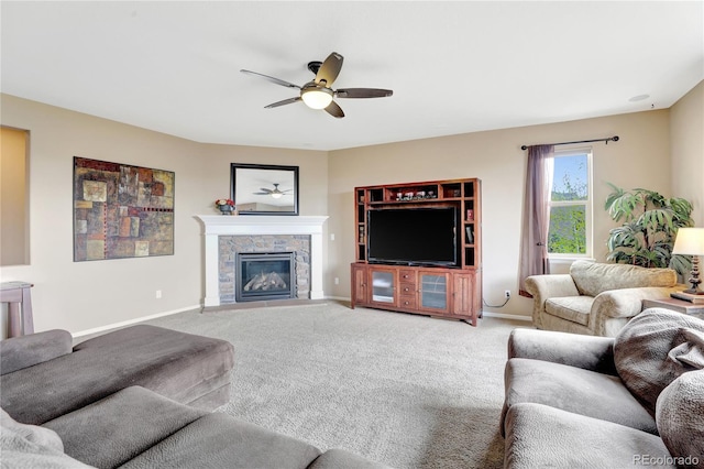 living room featuring ceiling fan, baseboards, carpet, and a fireplace