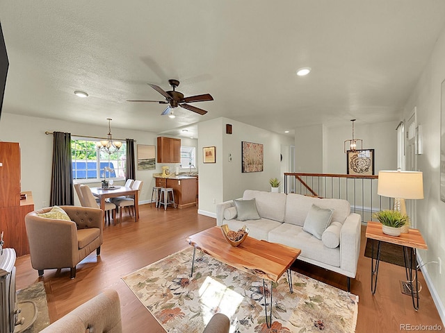 5319 E Davies Dr, Centennial, CO 80122 - living area featuring a chandelier, wood finished floors, a ceiling fan, and recessed lighting