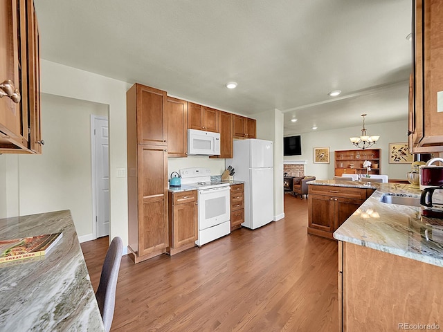 5319 E Davies Dr, Centennial, CO 80122 - kitchen with white appliances, a chandelier, dark wood-type flooring, a peninsula, and light stone countertops