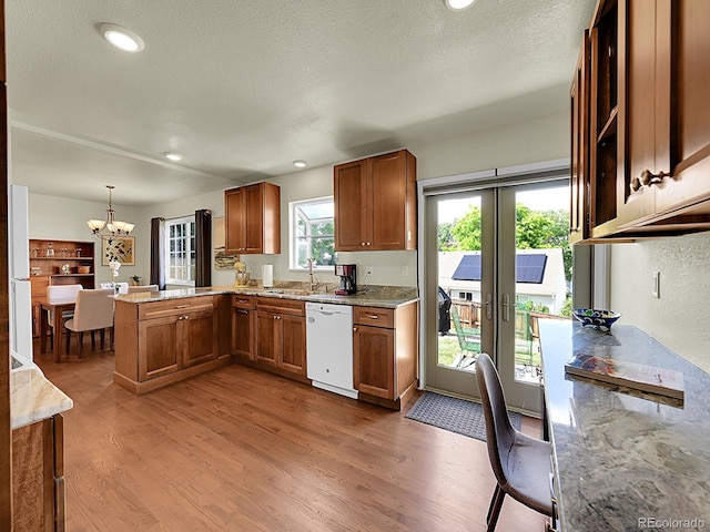 5319 E Davies Dr, Centennial, CO 80122 - kitchen featuring white dishwasher, a peninsula, wood finished floors, a chandelier, and brown cabinets