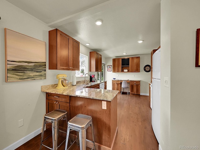 5319 E Davies Dr, Centennial, CO 80122 - kitchen featuring brown cabinets, open shelves, light stone counters, a peninsula, and wood finished floors