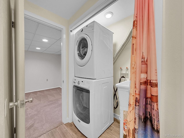 5319 E Davies Dr, Centennial, CO 80122 - laundry room with stacked washer and clothes dryer, recessed lighting, light colored carpet, and light wood finished floors