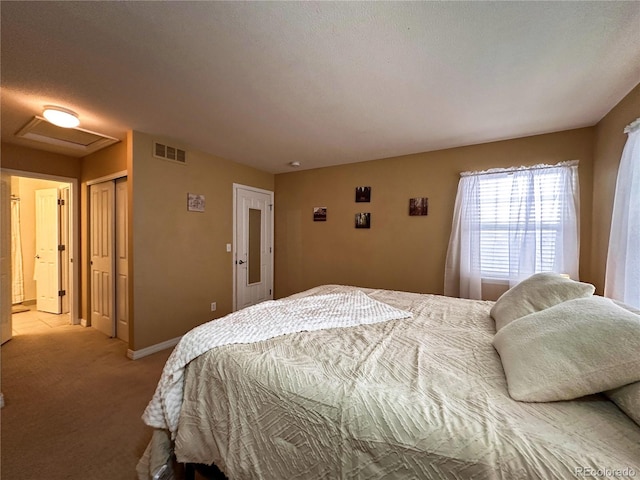 bedroom featuring a closet, a textured ceiling, and light carpet