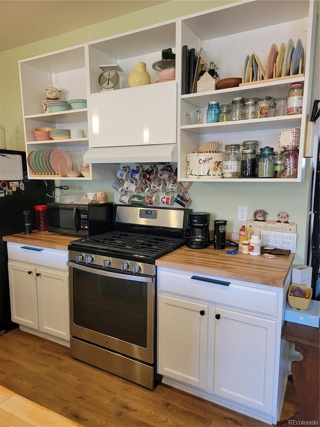 kitchen with open shelves, wooden counters, wood finished floors, and stainless steel range with gas stovetop