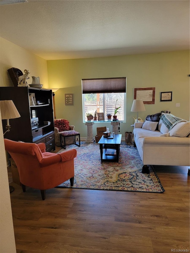 living area with a textured ceiling and wood finished floors