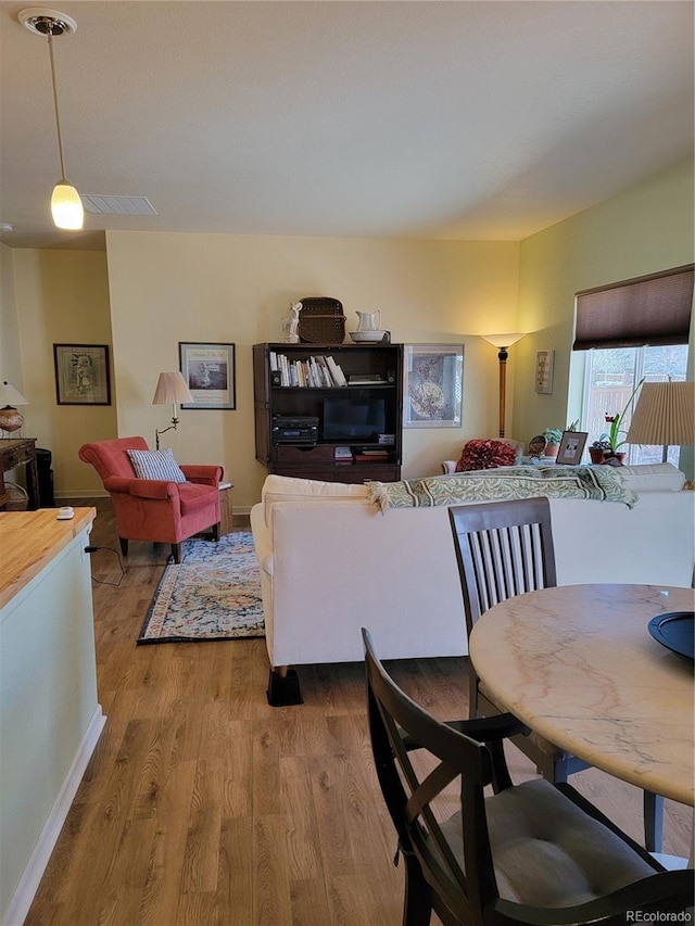 living area featuring visible vents and wood finished floors