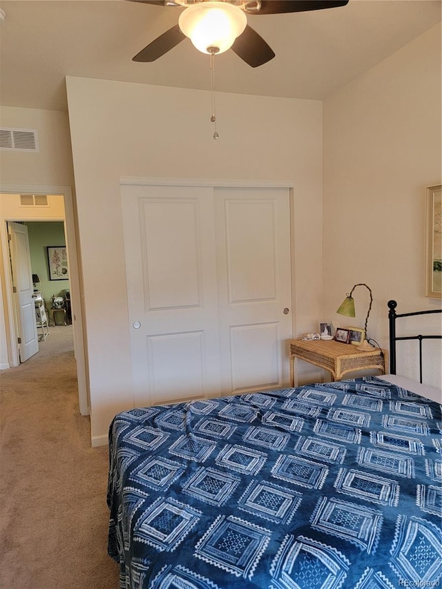 bedroom featuring light carpet, visible vents, a ceiling fan, baseboards, and a closet