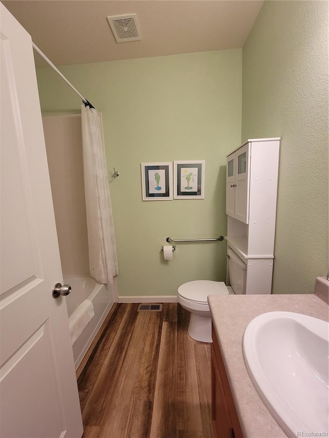 bathroom with toilet, visible vents, wood finished floors, and vanity