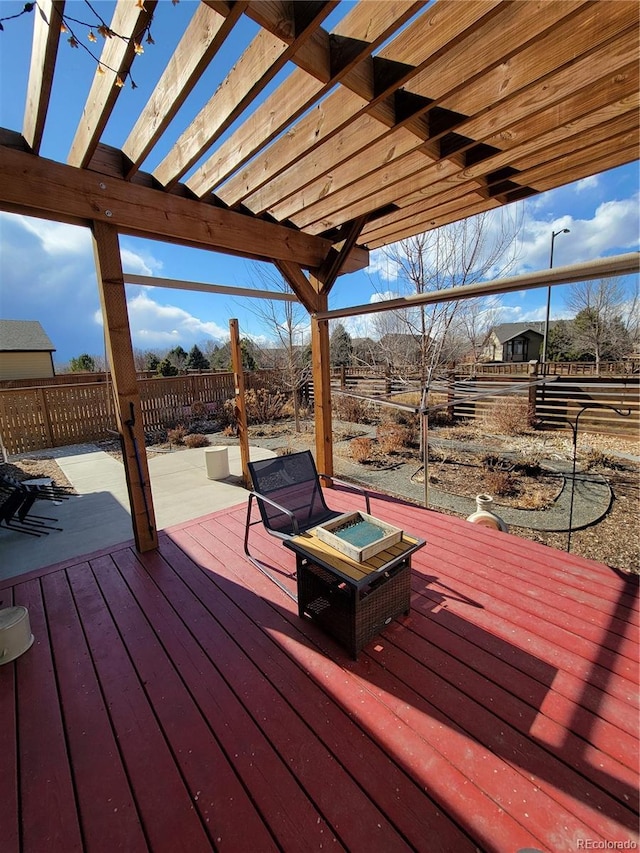 deck featuring an outdoor fire pit, fence, and a pergola