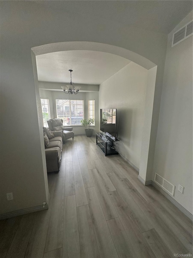 12235 E 2nd Dr, Aurora, CO 80011 - living room with arched walkways, a chandelier, and wood finished floors