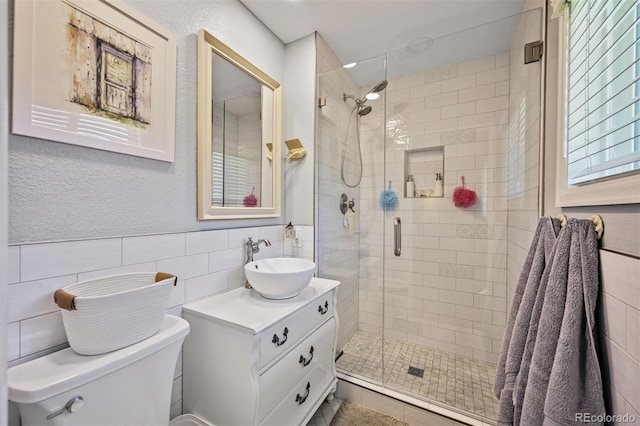 1733 S Urban Way, Lakewood, CO 80228 - full bath with a stall shower, toilet, vanity, tile walls, and a textured wall