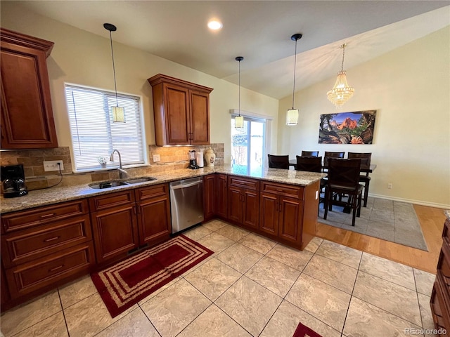 kitchen with tasteful backsplash, pendant lighting, sink, vaulted ceiling, and dishwasher