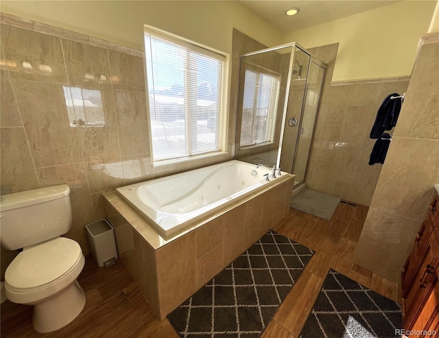 bathroom featuring wood-type flooring, toilet, and plus walk in shower