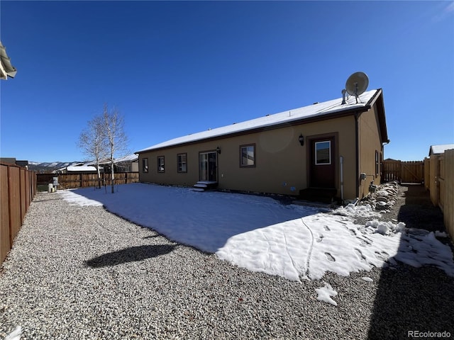 view of snow covered rear of property