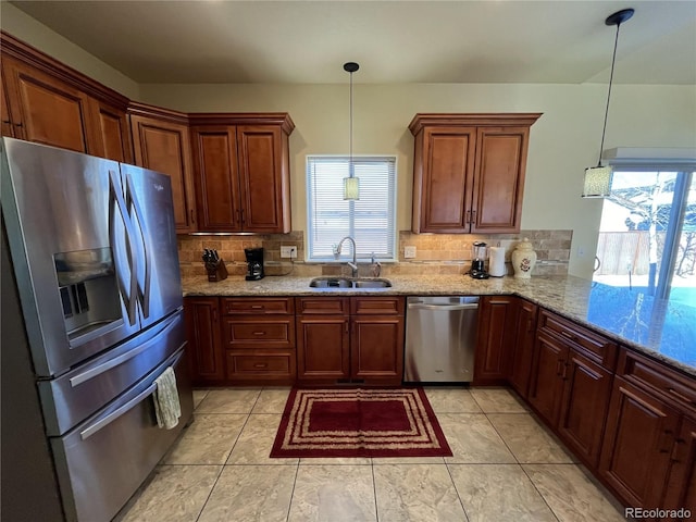 kitchen featuring a wealth of natural light, appliances with stainless steel finishes, hanging light fixtures, and sink