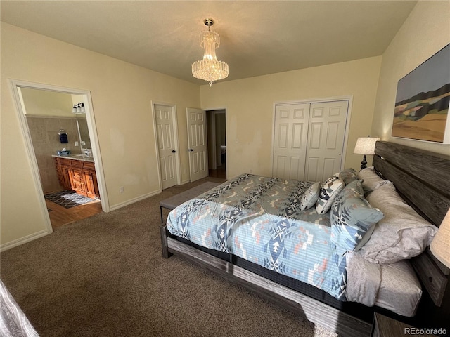 carpeted bedroom featuring a chandelier and ensuite bathroom