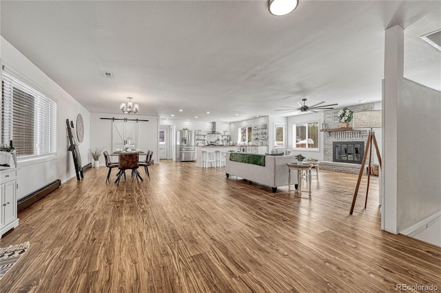 living room with a wealth of natural light, a fireplace, and hardwood / wood-style flooring