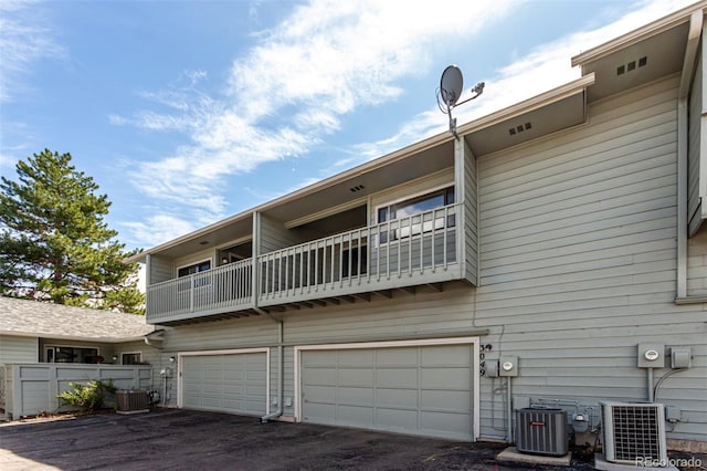 3049 E Long Cir S, Centennial, CO 80122 - rear view of house with a balcony, an attached garage, and asphalt driveway