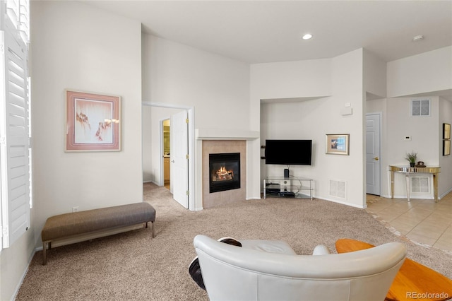 tiled living area with recessed lighting, visible vents, a fireplace, and carpet flooring