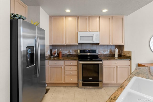 kitchen featuring decorative backsplash, light tile patterned floors, appliances with stainless steel finishes, and light brown cabinetry