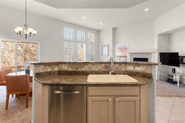 kitchen featuring open floor plan, light carpet, light tile patterned floors, a fireplace, and a sink