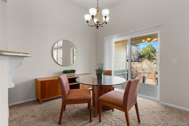 dining space featuring baseboards, light colored carpet, and a chandelier