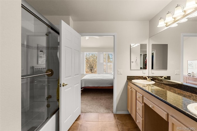 full bathroom featuring a sink, a shower with door, ensuite bath, tile patterned flooring, and double vanity