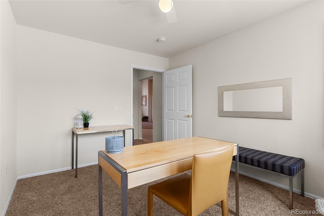 carpeted office featuring baseboards and a ceiling fan