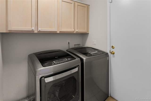 washroom featuring separate washer and dryer and cabinet space