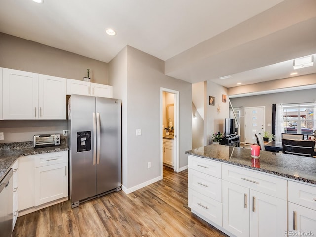 246 Ash St, Bennett, CO 80102 - kitchen featuring dark stone counters, baseboards, light wood finished floors, white cabinetry, and stainless steel fridge with ice dispenser