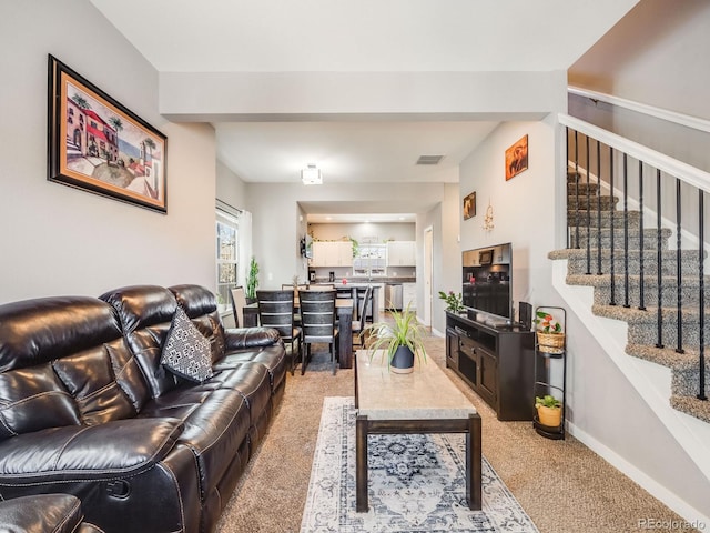 246 Ash St, Bennett, CO 80102 - living room with light carpet, baseboards, visible vents, and stairway