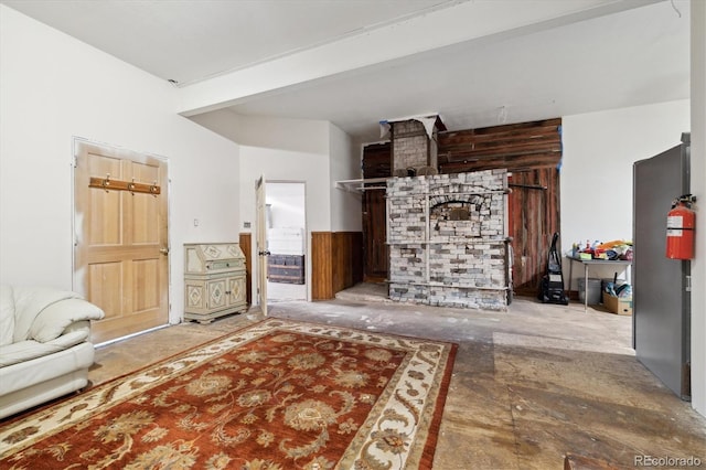 living room featuring beam ceiling and wooden walls