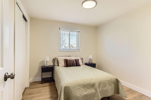 bedroom featuring a closet, baseboards, and light wood-style floors