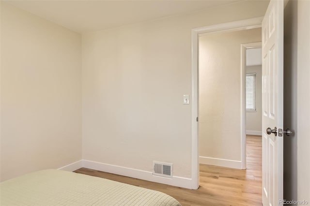 unfurnished bedroom featuring visible vents, baseboards, and light wood-style floors