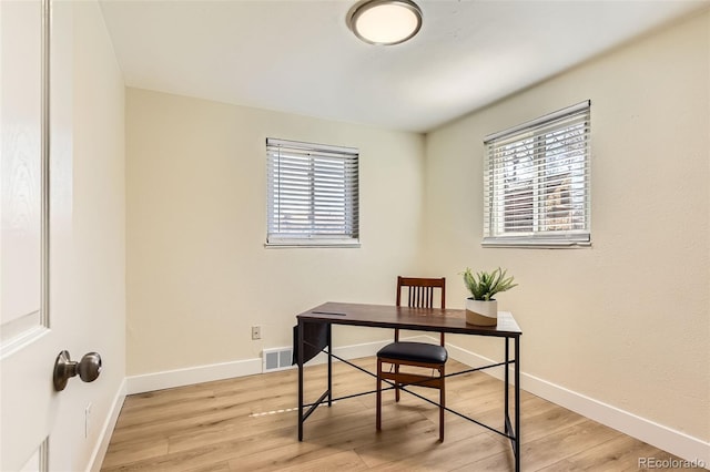 office space with visible vents, a healthy amount of sunlight, and light wood finished floors