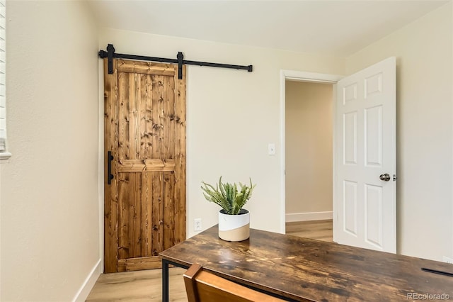 office space with light wood finished floors and a barn door