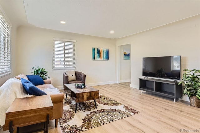 living area featuring light wood-style floors, baseboards, and recessed lighting