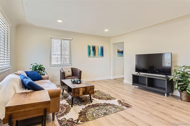 living area with recessed lighting, baseboards, and light wood finished floors