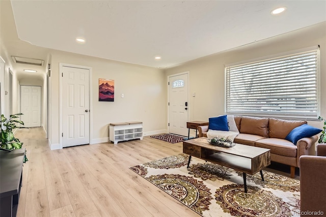 living room featuring light wood-style flooring, recessed lighting, and baseboards