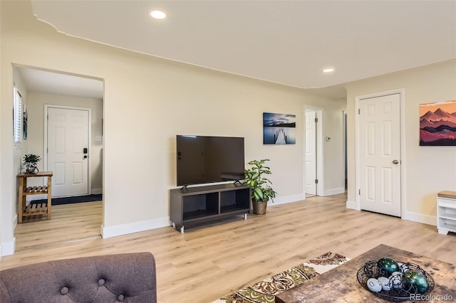 living room with recessed lighting, baseboards, and light wood-style floors